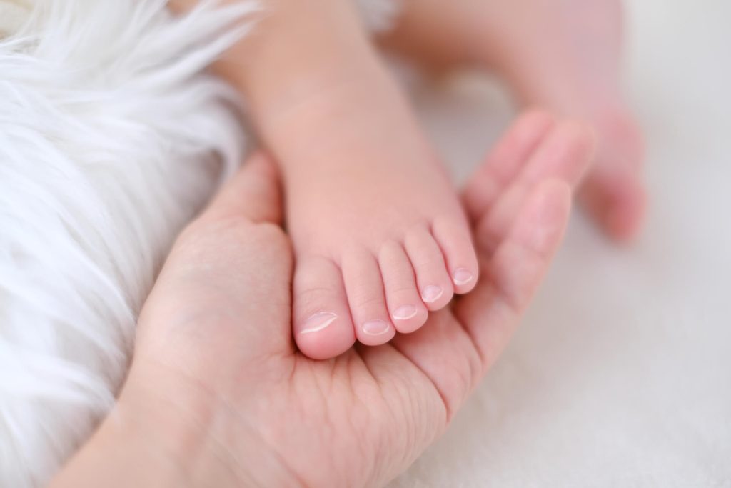赤腳睡覺嬰兒的腳和父母的手