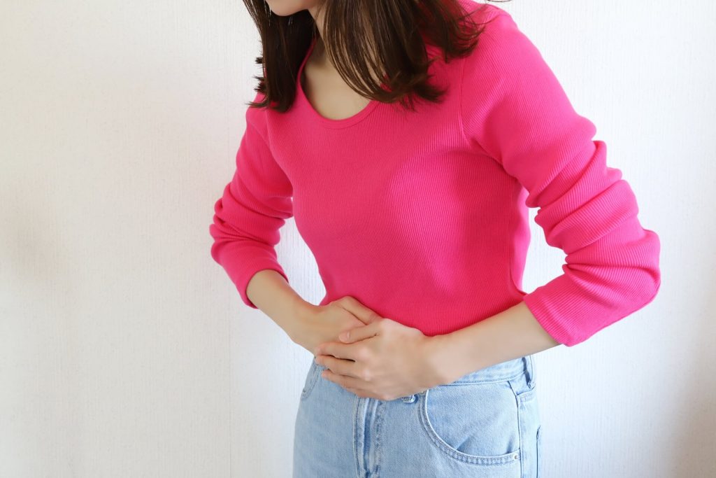 女人摀著肚子