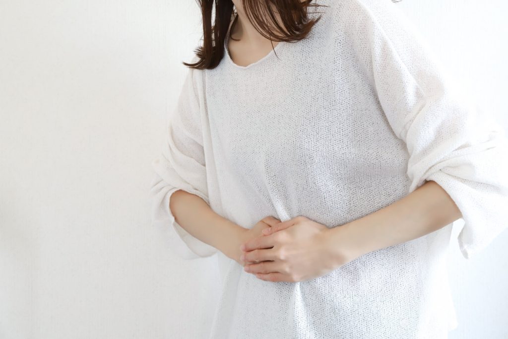 女人摀著肚子